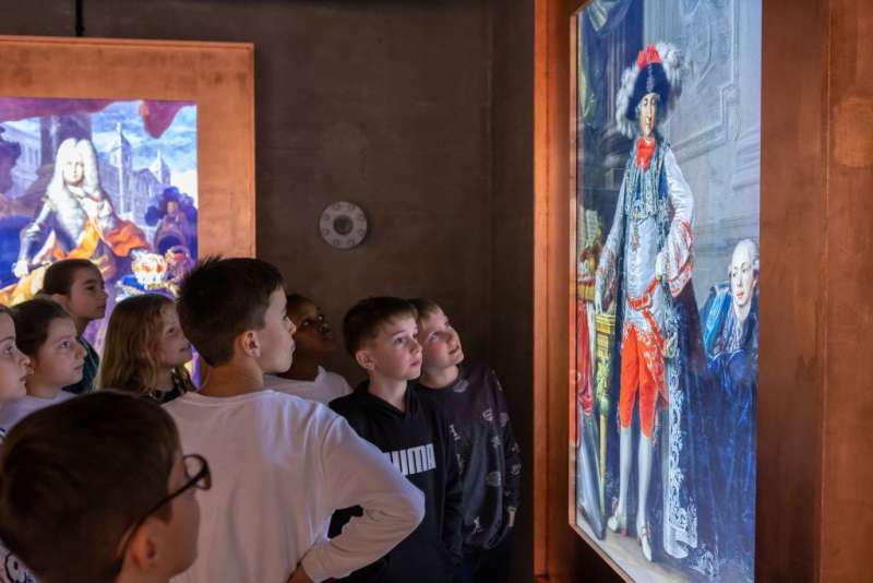 farbiges Bild von einer Kindergruppe, die sich ein Gemälde anschauen, auf dem der Mannheimer Kurfürst zu sehen ist